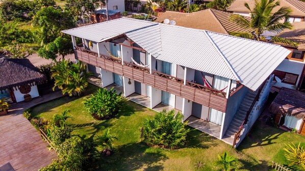 A two-story building with a flat roof, a balcony, and a staircase leading to the upper floor. - Pousada Barra Trip (Maraú)