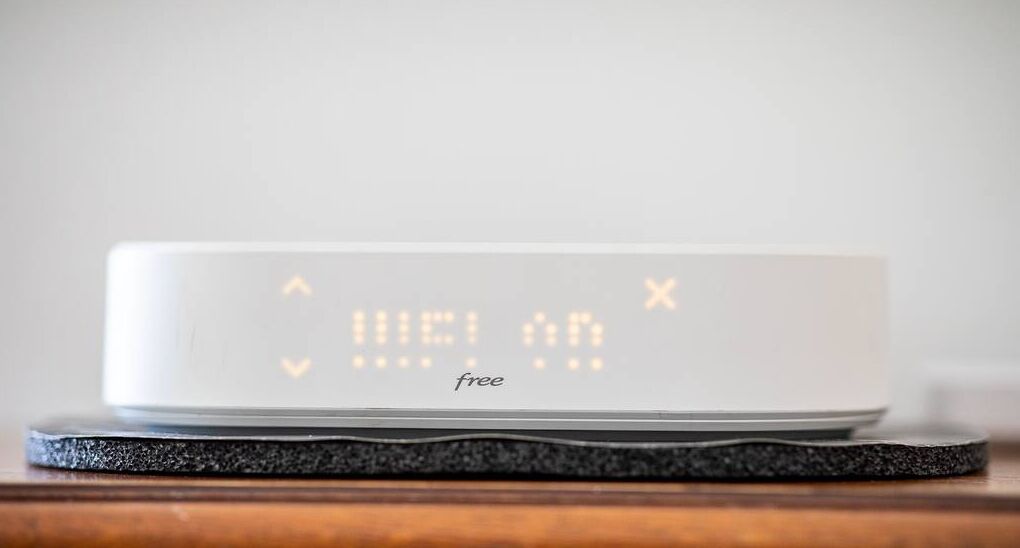 Une horloge numérique affichant « 11:21:45 » et le mot « gratuit » en dessous, posée sur une surface texturée.