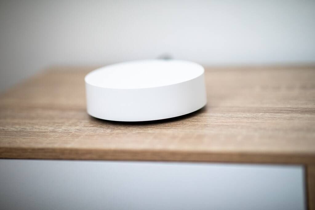 Un objet cylindrique blanc posé sur une surface en bois.