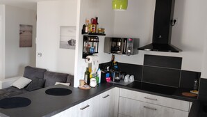 Een moderne keuken met een zwart aanrecht, witte kastjes en een inbouwoven.