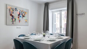 A dining area with a table set for six, a world map artwork on the wall, and a view of buildings through a window. - ART-POP groups, by MONARO***** (Madrid)