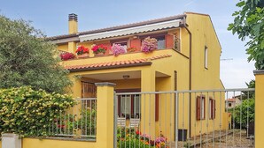 A yellow building with a balcony, a staircase, and a metal fence. - 2 bedroom amazing apartment in Riola Sardo (Riola Sardo)
