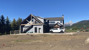 A large two-story house with a prominent front staircase and a garage.