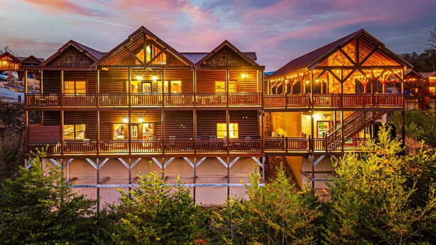 A multi-story log cabin-style hotel with balconies and a covered porch area.