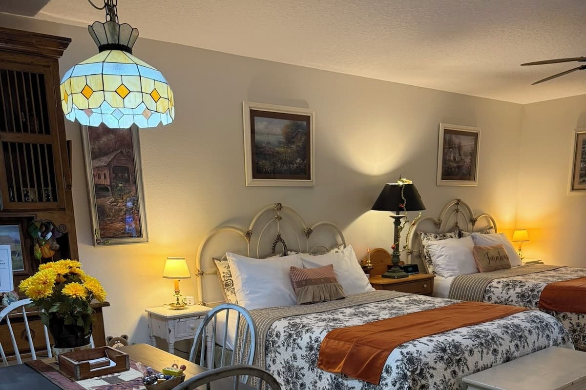 Une chambre à coucher avec un lit, des tables de chevet, un bureau et des chaises.