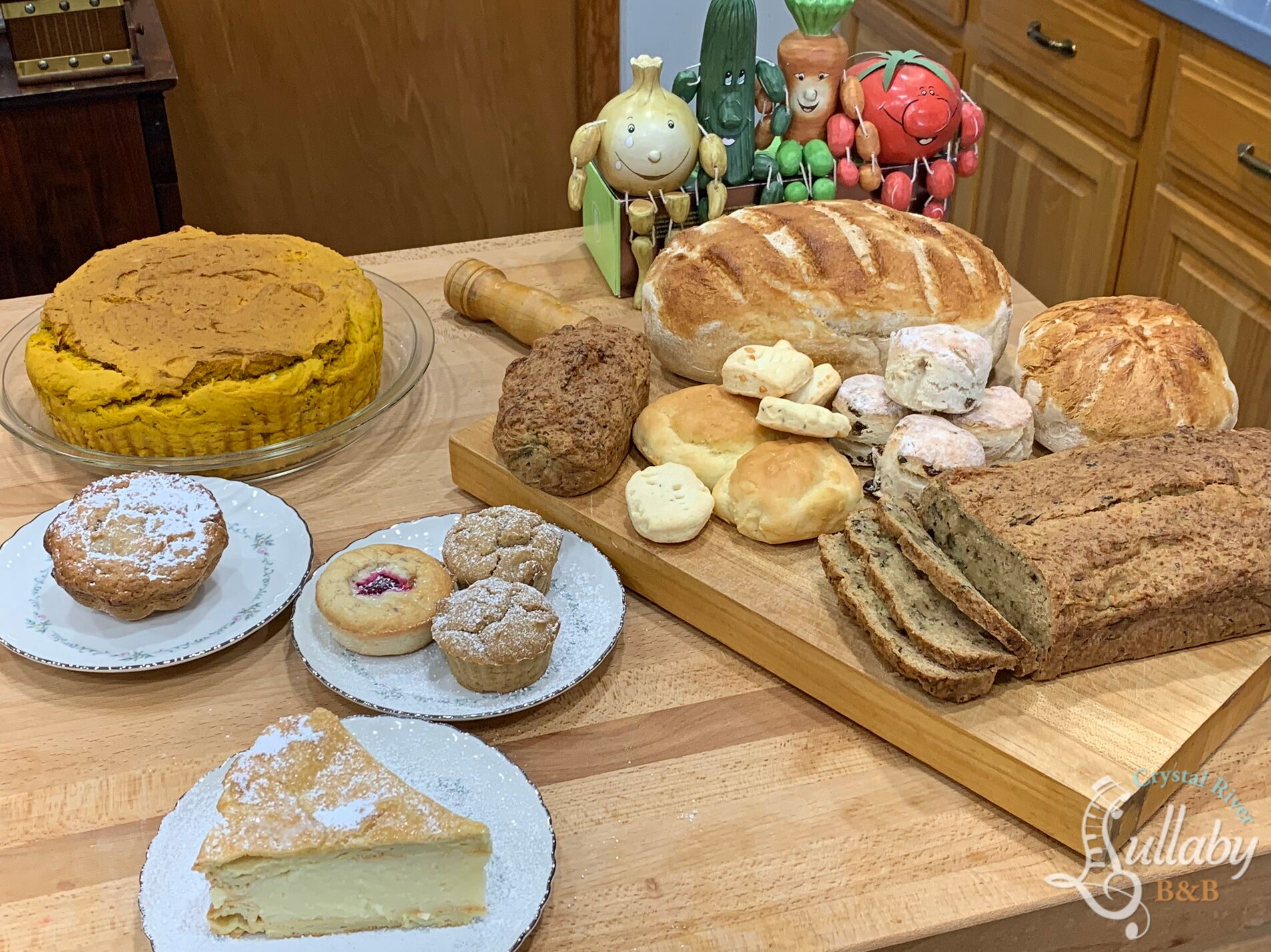 A variety of baked goods including cakes, pastries, and bread on a wooden table.