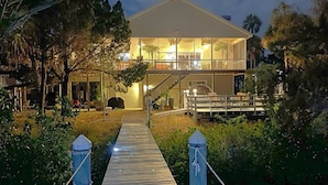 A two-story house with a covered porch and a wooden deck leading to the entrance. - Crystal River Lullaby B&B (Crystal River)