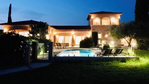 A large, two-story house with a swimming pool in the front yard.