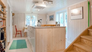 Een moderne keuken met houten kastjes, een centraal eiland en uitzicht op de omgeving.