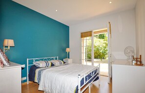 Cozy retreat with a bed, bedside tables, and lamps, offering a peaceful view of the surrounding greenery.