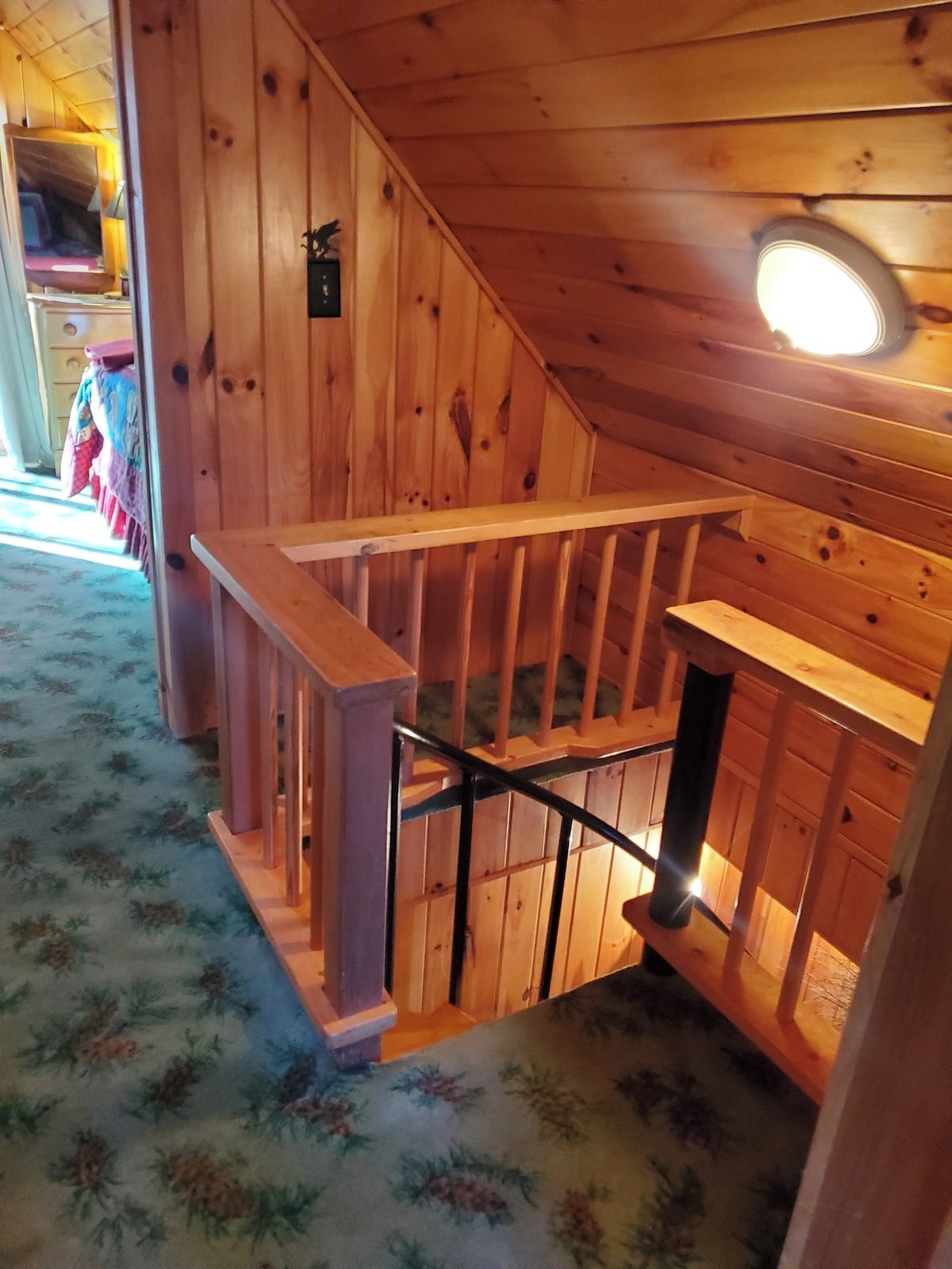 Eine Holztreppe mit Handlauf führt zu einem Bereich im zweiten Obergeschoss.