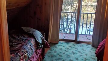 A room with a bed, a window, and a view of the outdoors.