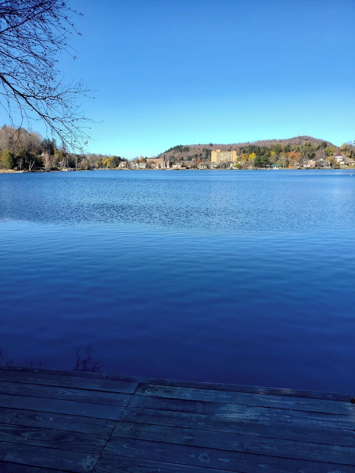Un lago tranquilo con un muelle de madera en primer plano.