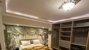 A bedroom with a bed, bedside table, chair, and a walk-in closet. - Lovely apartment in the heart of Cairo (Cairo Governorate)