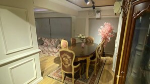 A dining area with a round table, chairs, and a floral centerpiece. - Lovely apartment in the heart of Cairo (Cairo Governorate)
