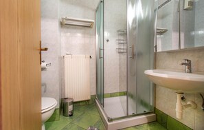 A bathroom with a toilet, a sink, a glass-enclosed shower, and a radiator. - Lovely apartment in Portoroz with house sea view (Portoroz)