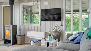 A cozy living room with a fireplace, a television, and a comfortable sofa. - Lovely home in Spøttrup (Spøttrup)