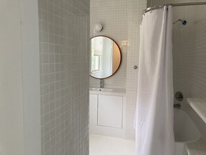 Tina con regadera, toallas, jabón, papel de baño 