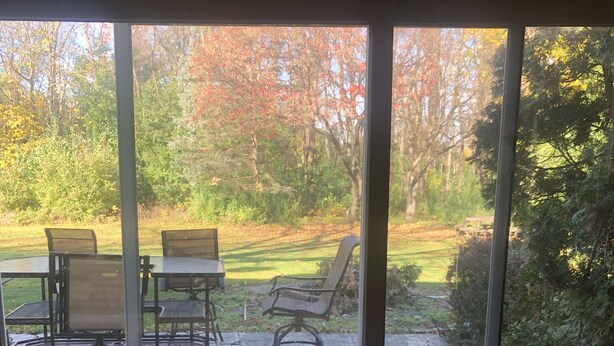 A patio with stone flooring and outdoor furniture, including chairs and a table. - EAA house on golf course (Oshkosh)
