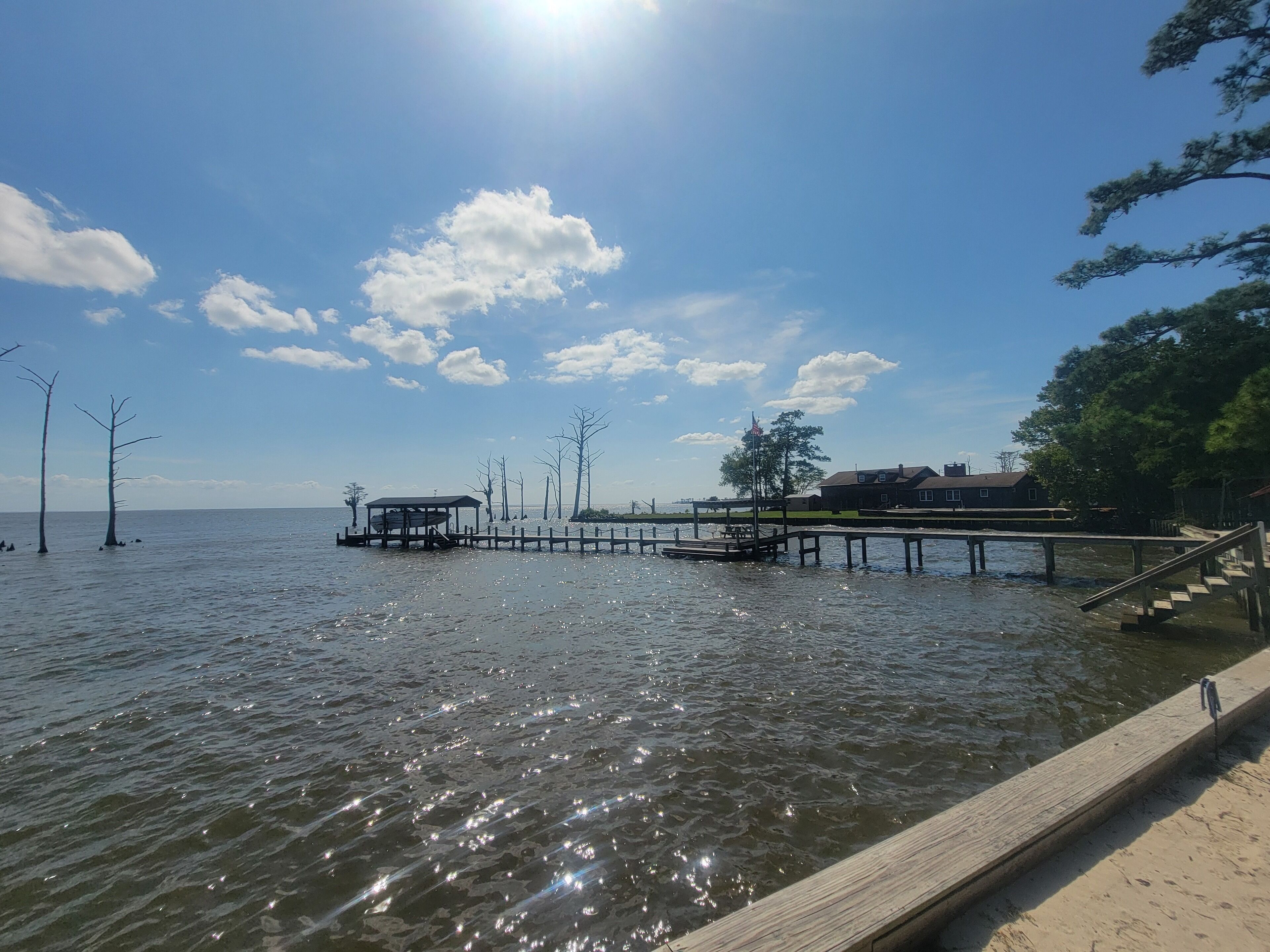 A wooden pier extending into a body of water with a clear sky above.