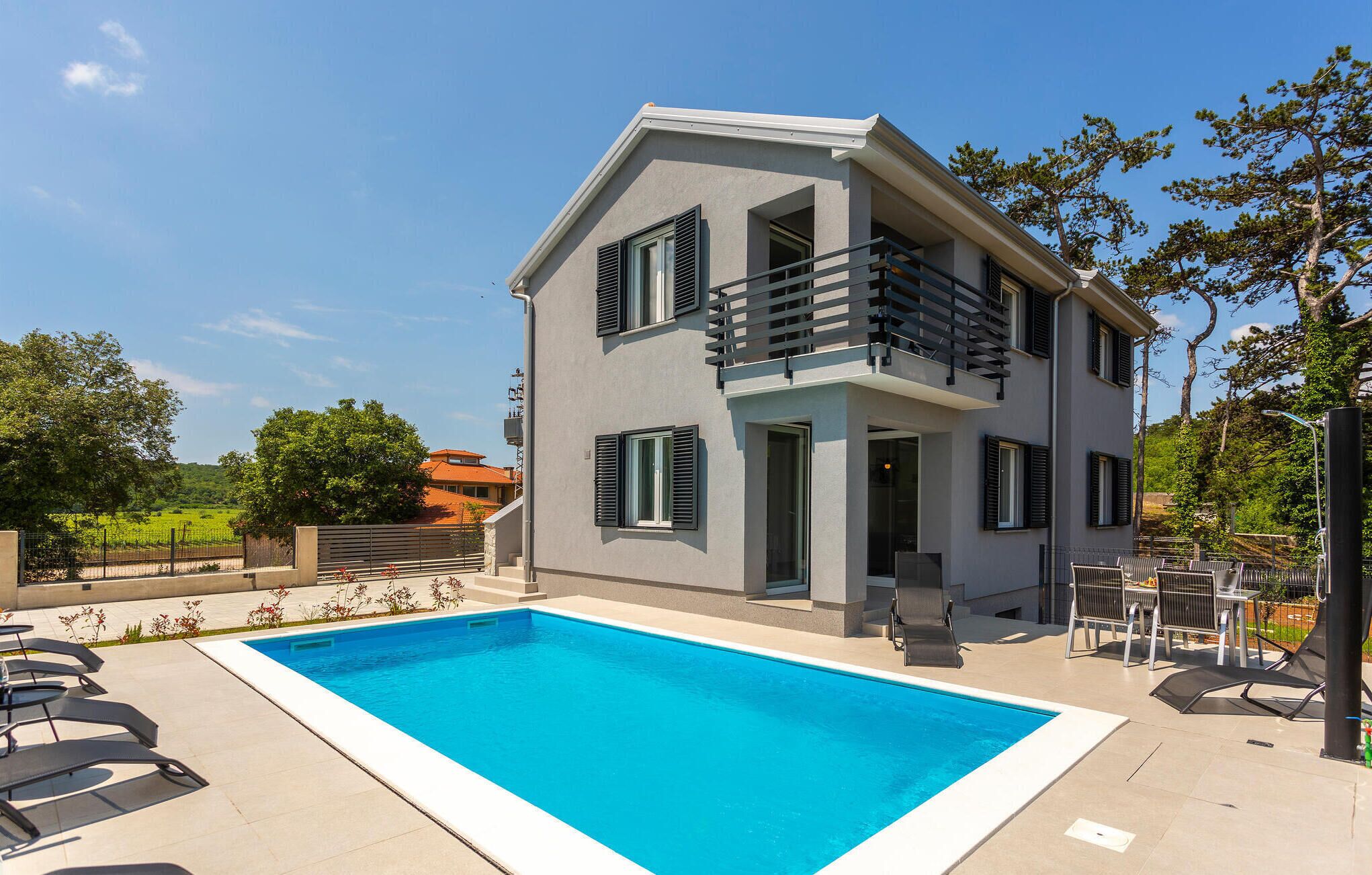 Ein zweistöckiges Gebäude mit Pool, Außenbereich und Blick auf die umliegende Landschaft.