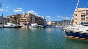 Un puerto deportivo con varios yates amarrados, rodeado de edificios de varios pisos con balcones.