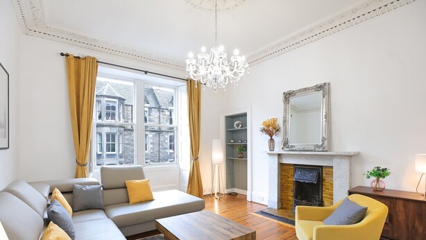 A living room with a sofa, armchair, wooden coffee table, and a fireplace. - A fabulous 2-bedroom apartment in the heart of Edinburgh (Edinburgh)