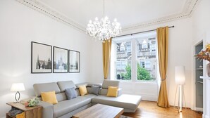 A modern living room with a grey sectional sofa, wooden coffee table, and a chandelier. - A fabulous 2-bedroom apartment in the heart of Edinburgh (Edinburgh)