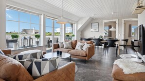 A spacious living area with a high ceiling, large windows, and a view of the outdoors. - Beautiful home in Ringkøbing with sauna (Ringkøbing)