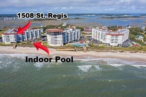 A coastal hotel with multiple buildings, an indoor pool, and a beach view. - 3BR Oceanfront Condo in NTB with Elevator & Community Pool (North Topsail Beach)