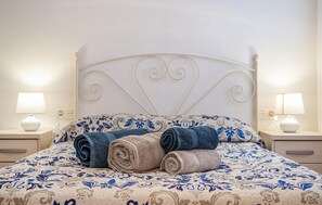 A neatly made bed with a patterned bedspread, two bedside lamps, and rolled towels on the bed. - Gorgeous apartment in San Javier (San Javier)