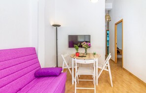A room with a purple sofa, a small table with chairs, a TV, and a floor lamp. - Gorgeous apartment in San Javier (San Javier)