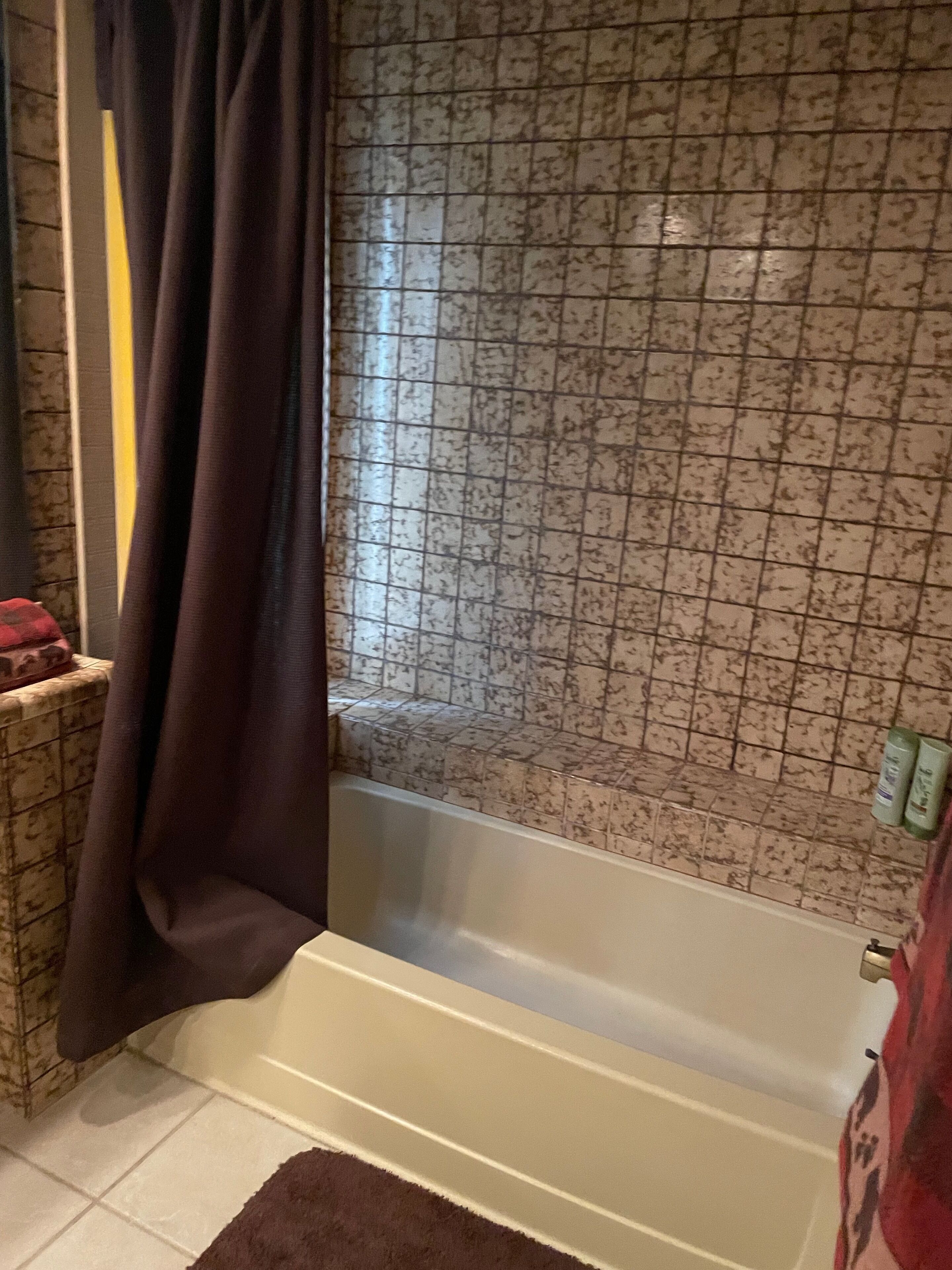 A bathroom with a bathtub, a window with a view, and a towel rack.