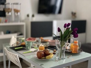 A breakfast table with fruits, a vase with flowers, and a juice pitcher. - Syracuse, Syracuse Center (Siracusa)