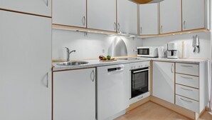 A modern kitchen with white cabinets, a stainless steel sink, a microwave, a coffee maker, and a dishwasher. - Nice home in Gråsten with WiFi (Gråsten)