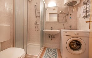 A bathroom with a toilet, a shower, a sink, and a washing machine. - Beautiful apartment in Portoroz (Portoroz)