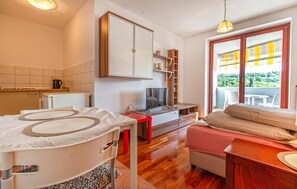 Relax in a cozy living space with a kitchenette, flat-screen TV, and comfortable seating area overlooking a serene outdoor view.