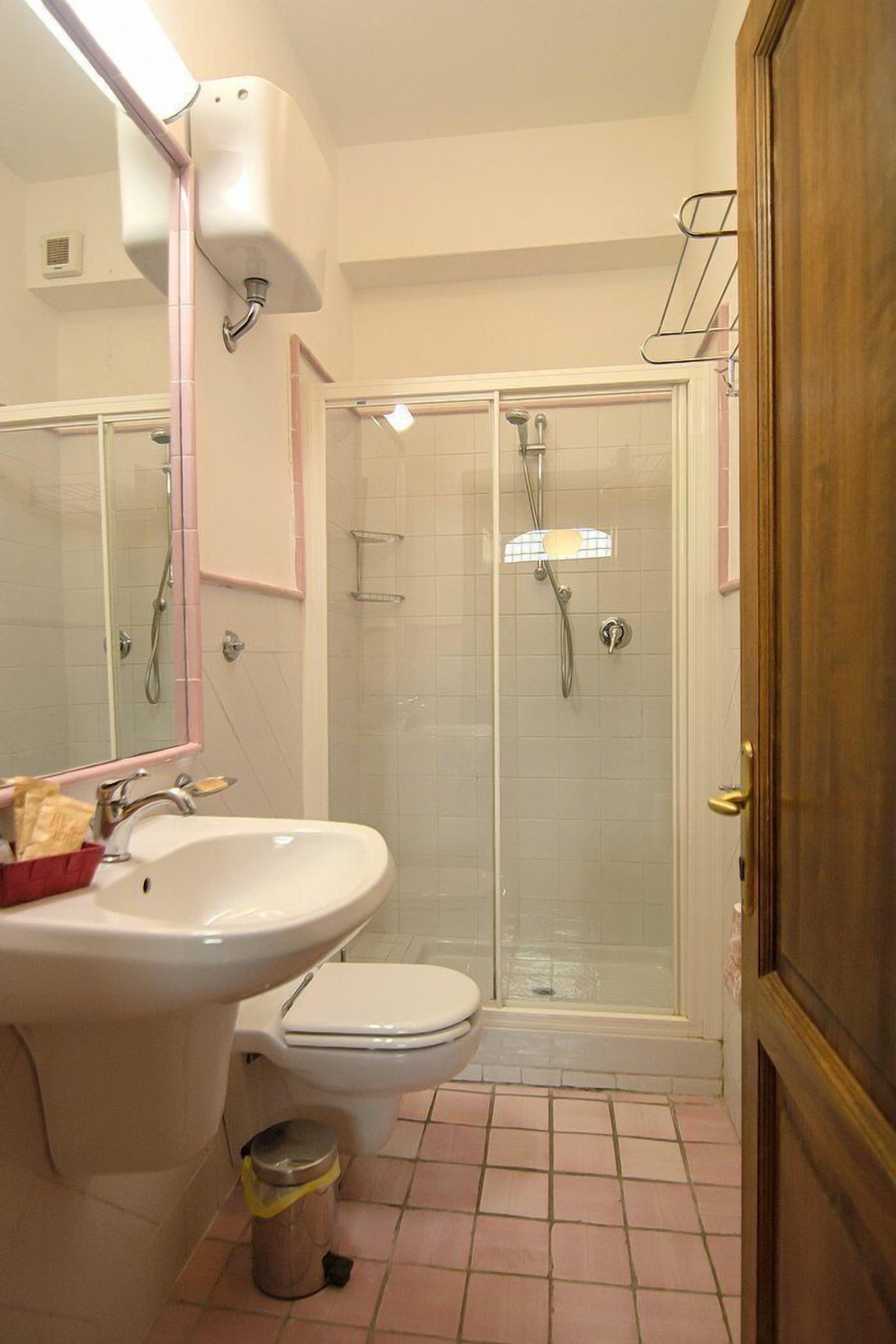 Une salle de bain équipée d’un lavabo, de toilettes et d’une douche à parois de verre.