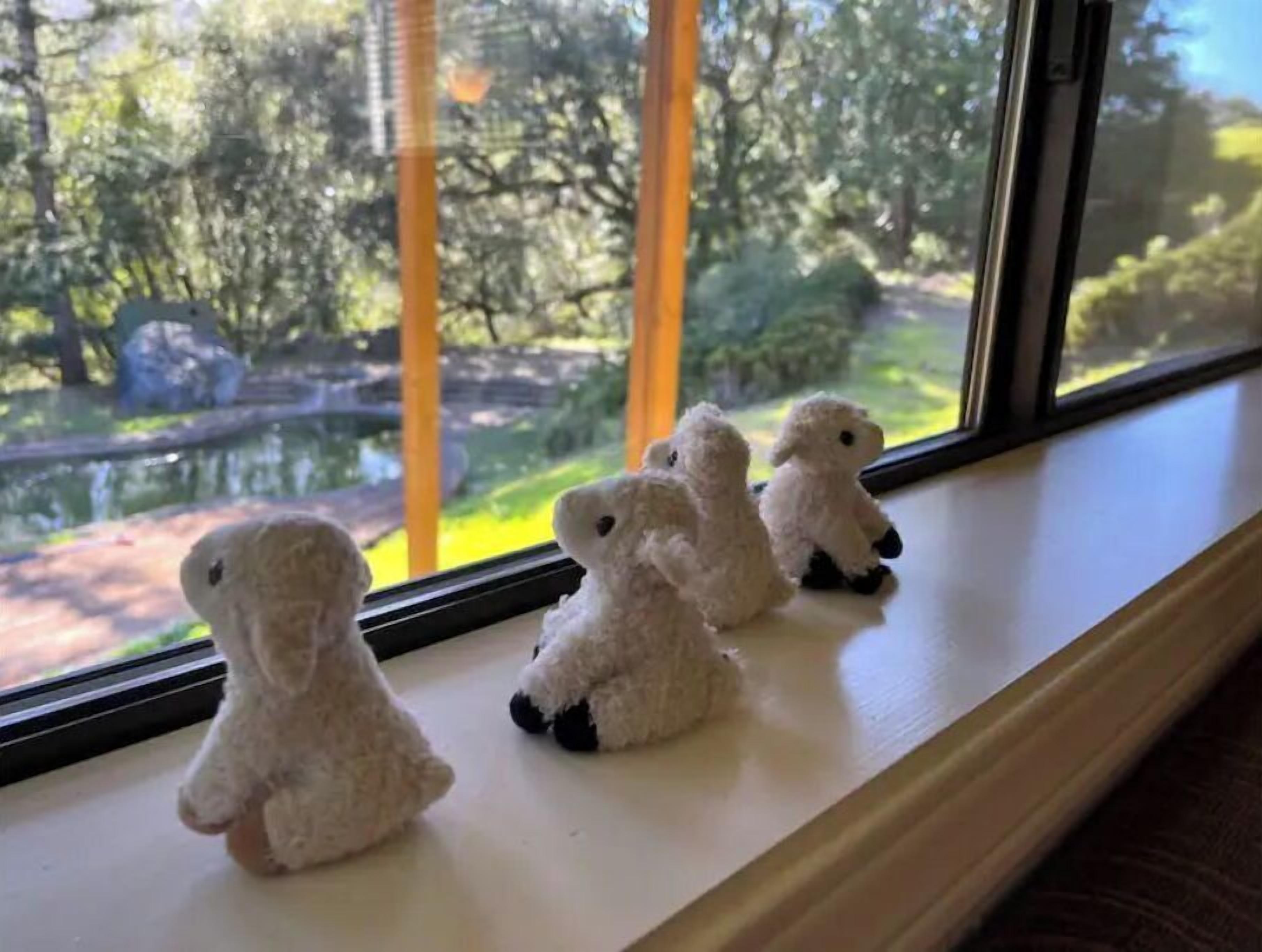 A window sill with four small white figurines.