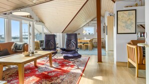 Een ruim loft met hoge plafonds, een eethoek en uitzicht op de omgeving.