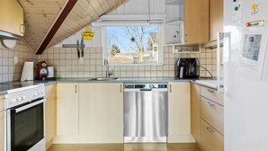 Een moderne keuken met een houten plafond, een vaatwasser, een koffiezetapparaat en een koelkast.