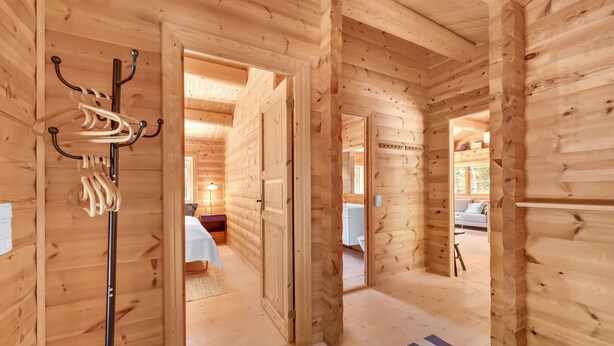 A wooden cabin interior with a bed, a nightstand, and a lamp. - Cozy home in Ulfborg with kitchen (Ulfborg)