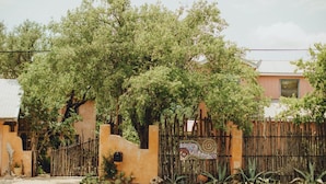 Un quartier résidentiel avec une clôture en bois, une fresque colorée et une maison à la façade rose.