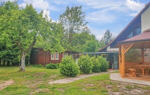 Enjoy a peaceful retreat in a serene backyard with a well-maintained lawn and a traditional brick building.