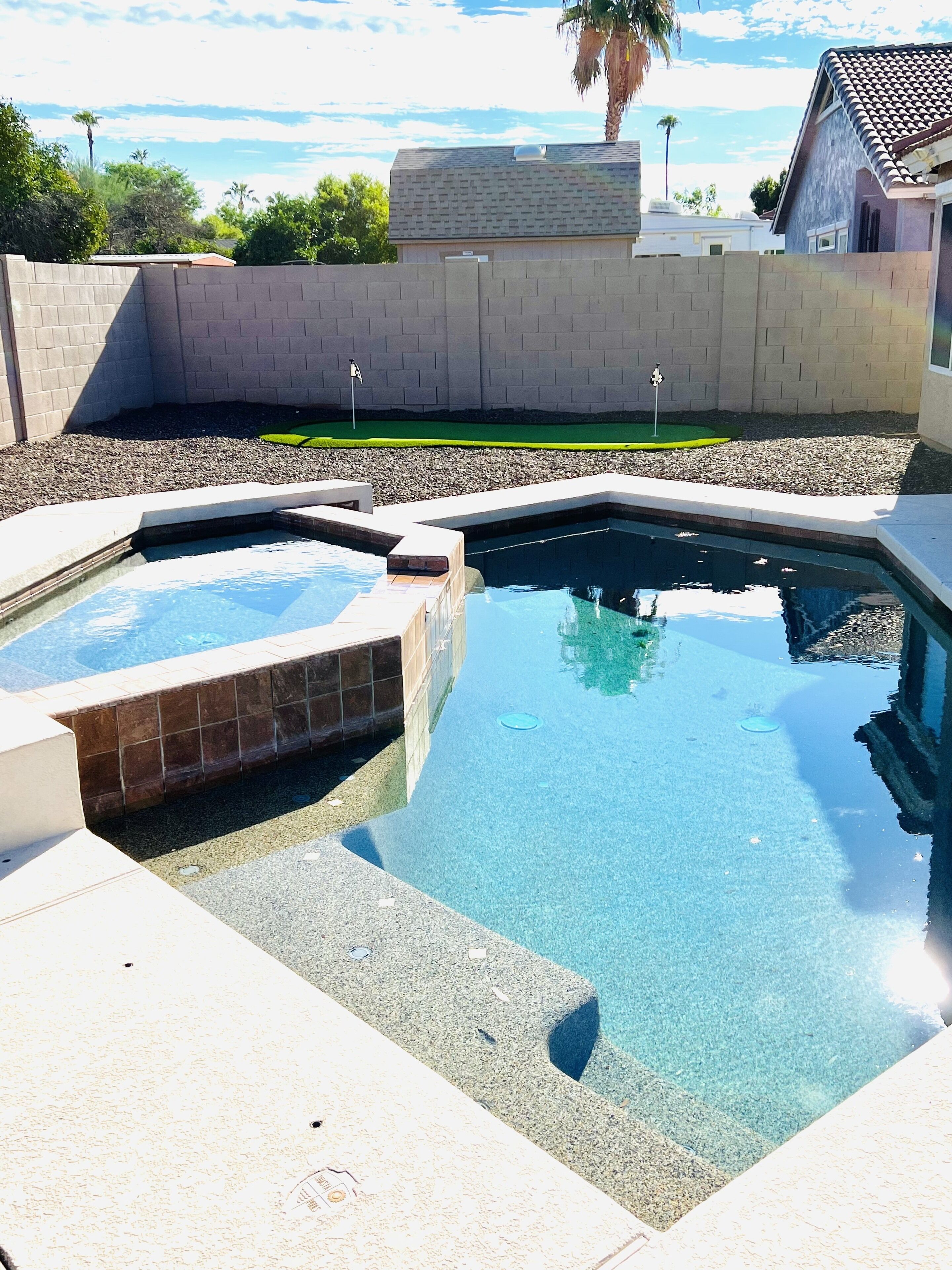 Una piscina con vista despejada al cielo y follaje circundante.