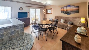Un'accogliente zona living con un tavolo da pranzo rotondo, un divano e una TV.