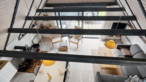 En modern inredning med ett matområde, en soffa och utsikt över omgivningen.