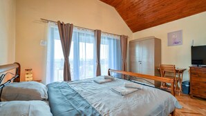 Une chambre à coucher comprenant un lit, un bureau, une chaise, une armoire et un téléviseur.