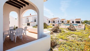 A white building with arches and a pool area. - Rimar 6, 2 bedroom apartment, Cap d´Artrutx (Cala´n Bosch)