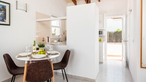 A dining area with a round table, chairs, and a white cabinet in the background. - Rimar 6, 2 bedroom apartment, Cap d´Artrutx (Cala´n Bosch)